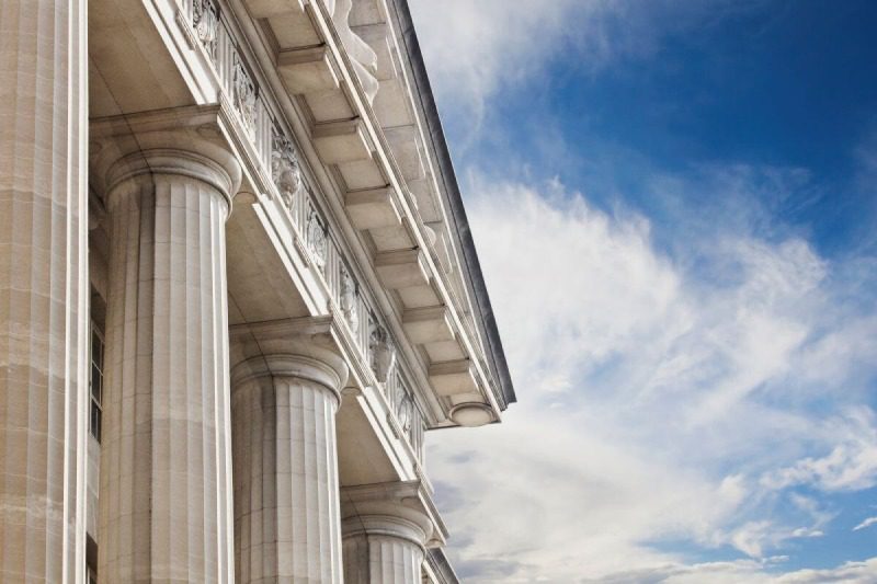 A building with columns and a blue sky.