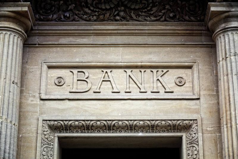 A bank building with pillars and a sign that says bank.